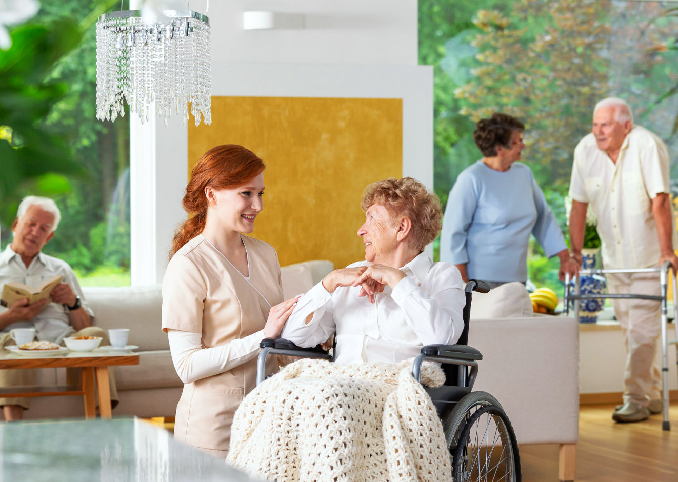 senior woman on a wheelchair smiling at her caregiver